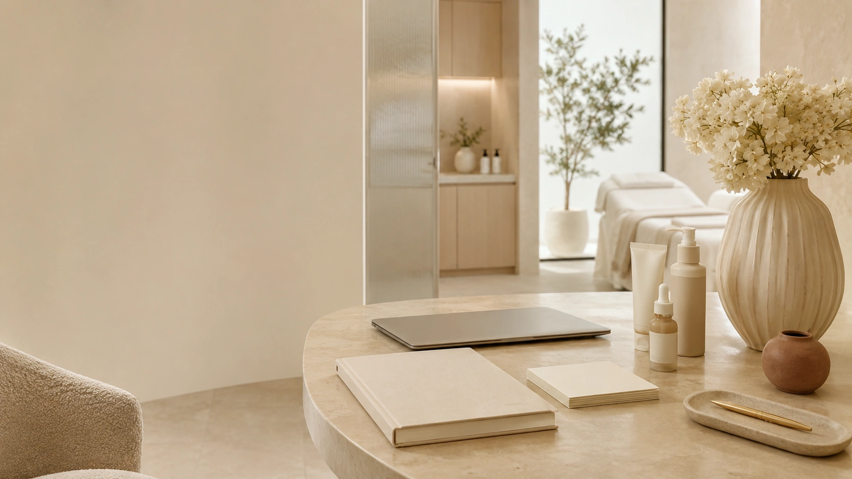Calm Aesthetics by Clouds consultation room with skincare objects, notebook, laptop and flowers